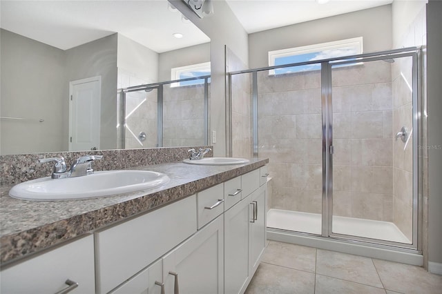 bathroom featuring a shower with door, tile patterned flooring, and vanity