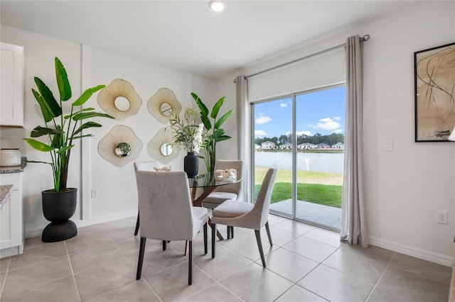 dining room featuring a water view and light tile patterned floors