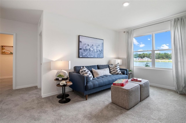 living room featuring light colored carpet and a water view