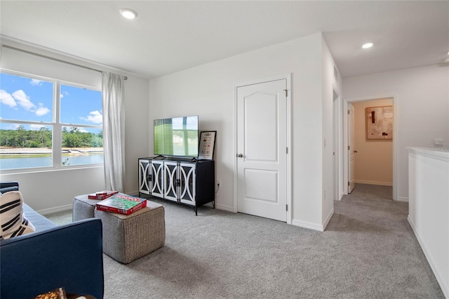 interior space featuring light colored carpet and a water view