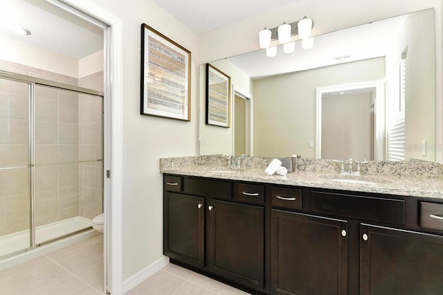 bathroom featuring vanity, toilet, a shower with shower door, and tile patterned flooring