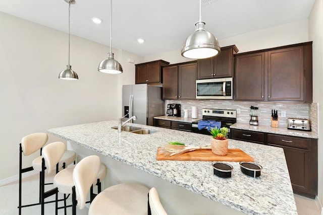 kitchen with a center island with sink, backsplash, and appliances with stainless steel finishes