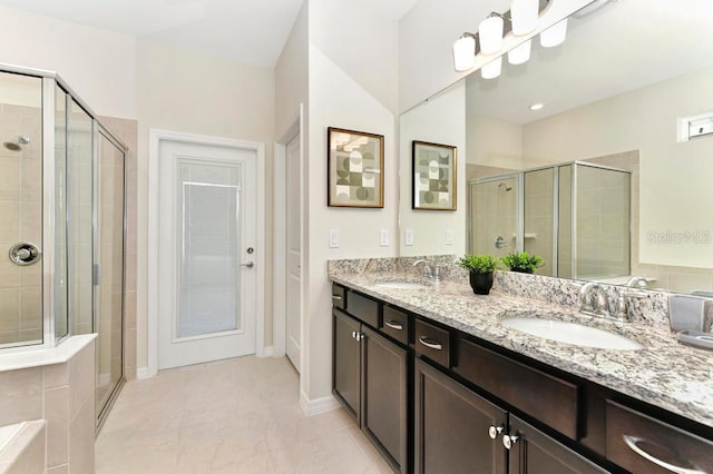 bathroom featuring a shower with shower door and vanity