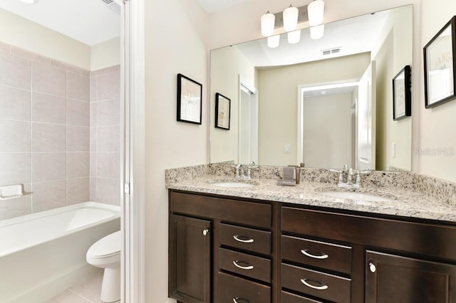 full bathroom with toilet, tile patterned flooring, tiled shower / bath, and vanity