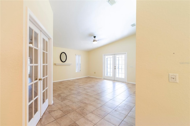 tiled empty room with ceiling fan, french doors, and vaulted ceiling