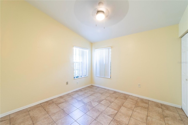 tiled empty room featuring vaulted ceiling and ceiling fan