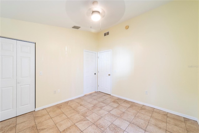 unfurnished bedroom featuring ceiling fan, light tile patterned floors, and a closet