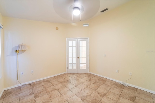 tiled empty room featuring ceiling fan and french doors