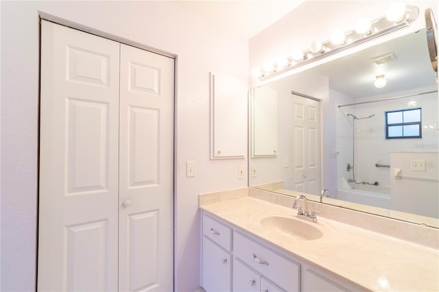 bathroom with tiled shower / bath combo and vanity