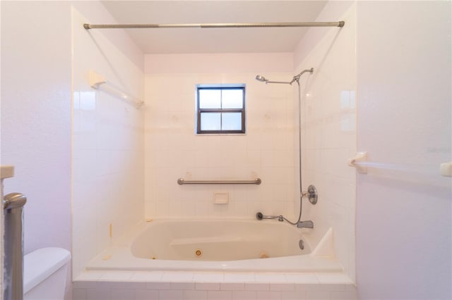 bathroom featuring toilet and tiled shower / bath