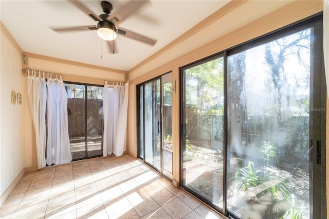 doorway to outside featuring light tile patterned floors, a wealth of natural light, crown molding, and ceiling fan