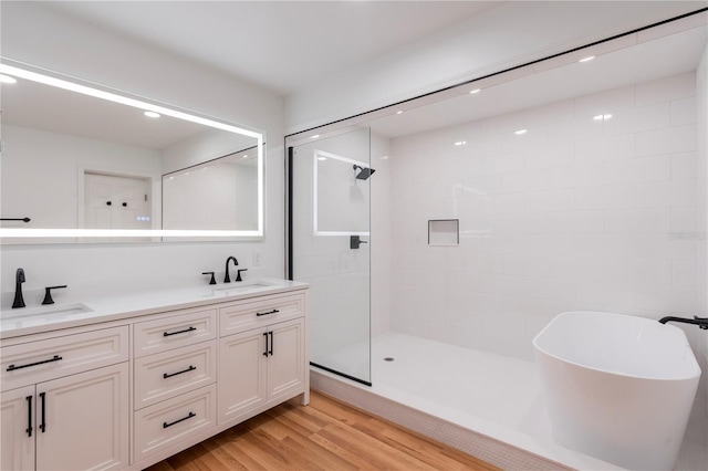 bathroom with vanity, wood-type flooring, and shower with separate bathtub