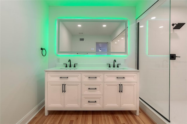 bathroom featuring vanity, hardwood / wood-style floors, and a tile shower