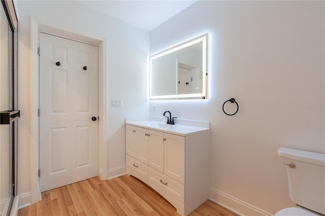 bathroom with vanity, toilet, and hardwood / wood-style floors