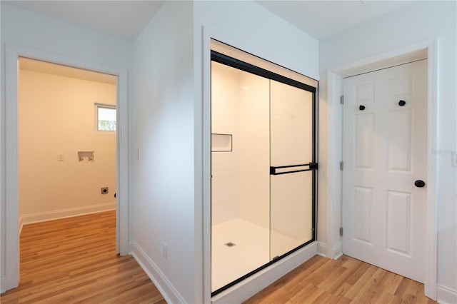 bathroom featuring wood-type flooring and a shower with door