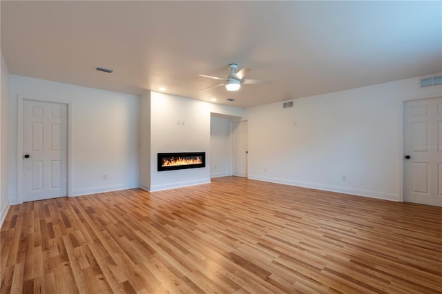 unfurnished living room featuring ceiling fan and light hardwood / wood-style flooring