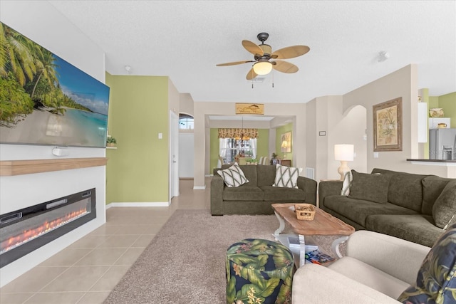 living room with light tile patterned floors, a textured ceiling, and ceiling fan