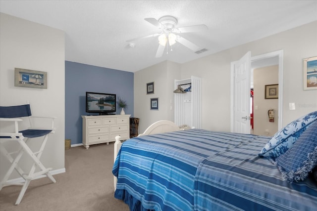 bedroom with ceiling fan, carpet flooring, and a textured ceiling