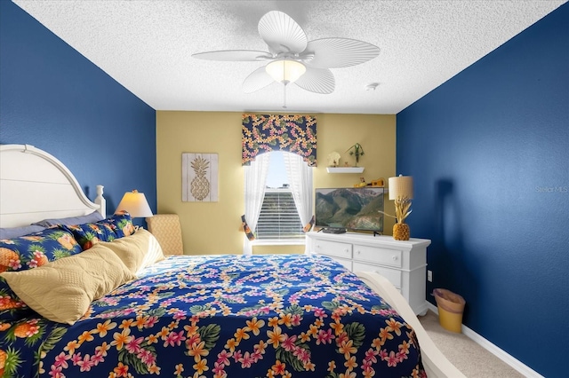 bedroom with ceiling fan, carpet floors, and a textured ceiling