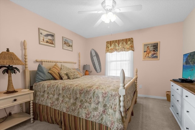 bedroom with a textured ceiling, light colored carpet, and ceiling fan