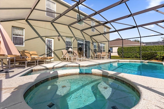 view of swimming pool with an in ground hot tub, glass enclosure, and a patio