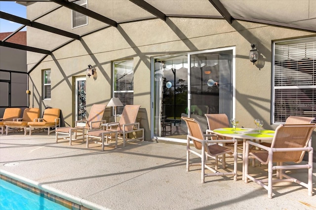 view of patio featuring glass enclosure