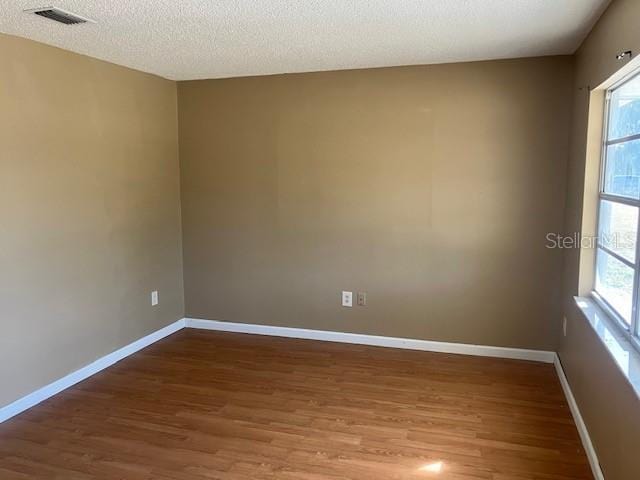 empty room featuring hardwood / wood-style floors and a textured ceiling