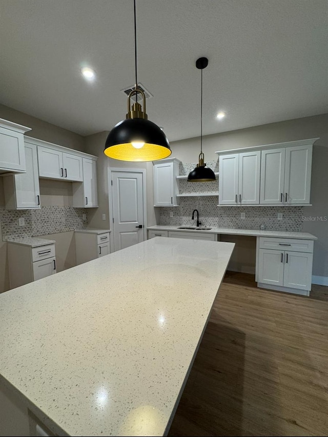 116 E Cleveland St, Apopka, FL 32703 - kitchen with dark wood finished floors, white cabinetry, tasteful backsplash, and a sink
