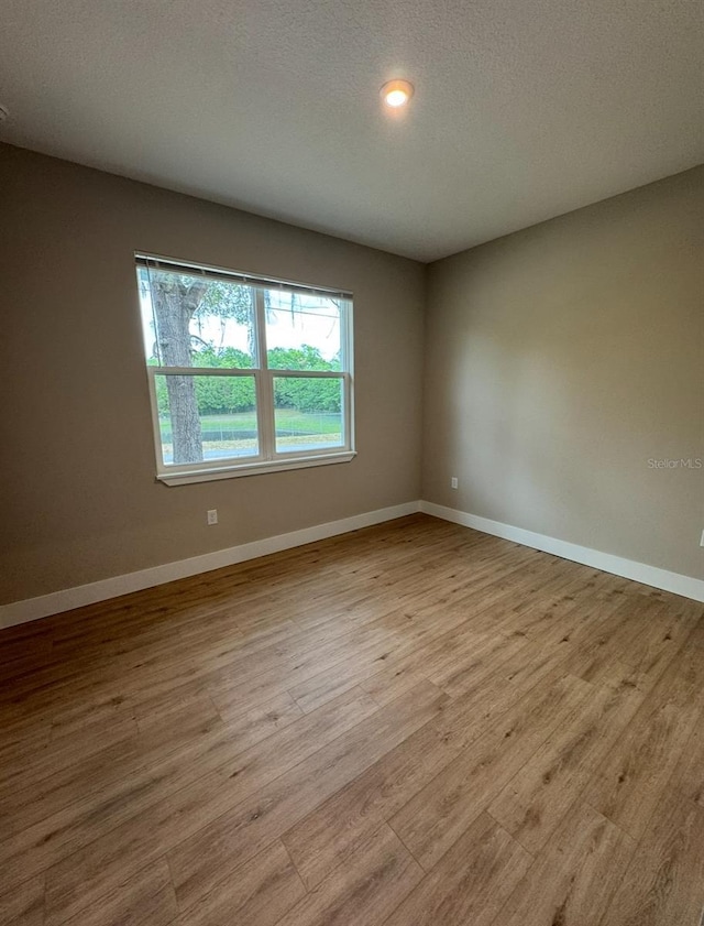 116 E Cleveland St, Apopka, FL 32703 - spare room featuring baseboards, wood finished floors, and a textured ceiling