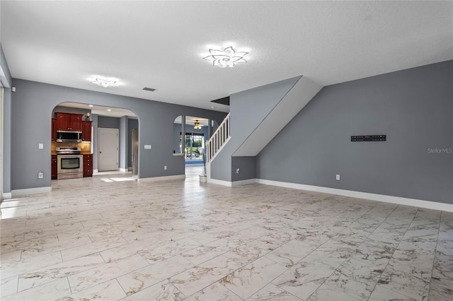 unfurnished living room with baseboards, arched walkways, visible vents, stairway, and marble finish floor