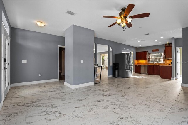 unfurnished living room featuring arched walkways, marble finish floor, recessed lighting, visible vents, and baseboards