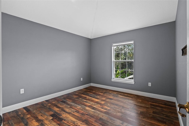 empty room featuring baseboards and dark wood finished floors