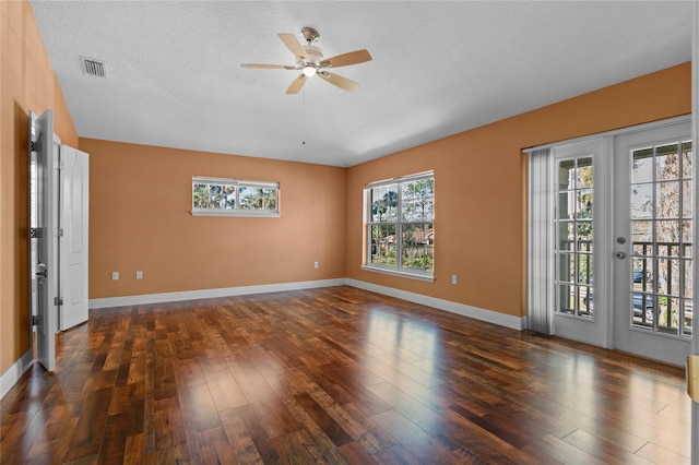 spare room with a textured ceiling, french doors, wood finished floors, and visible vents