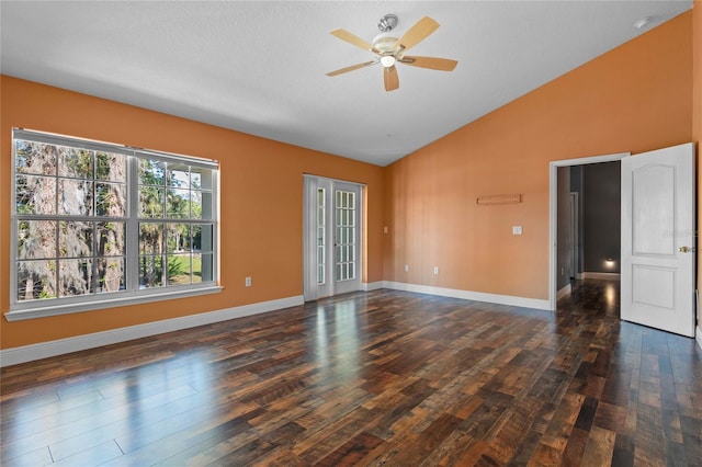 empty room featuring lofted ceiling, a ceiling fan, baseboards, and dark wood-type flooring