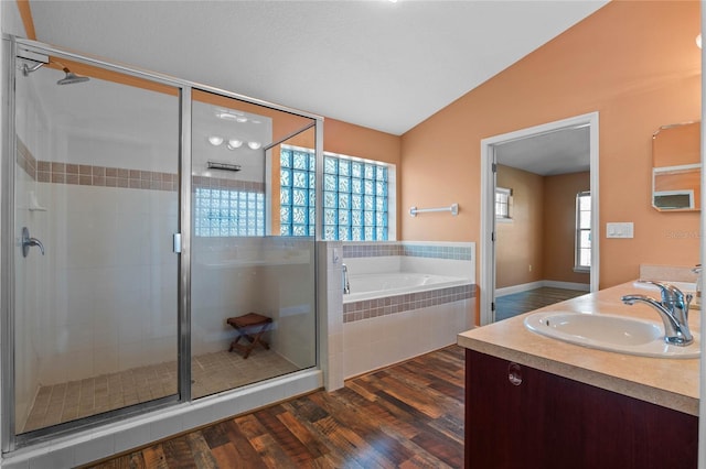 full bath featuring lofted ceiling, wood finished floors, a shower stall, and a bath