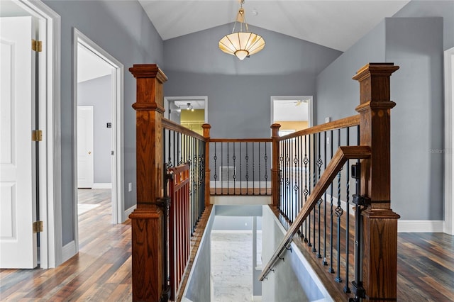 stairs with vaulted ceiling, wood finished floors, and baseboards