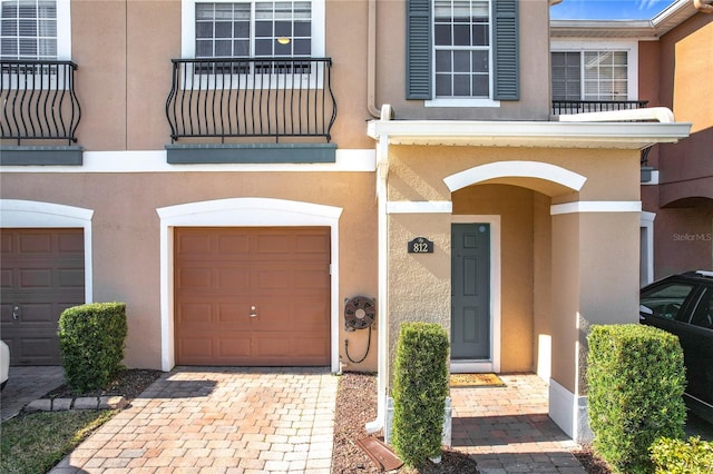 property entrance featuring a garage and a balcony