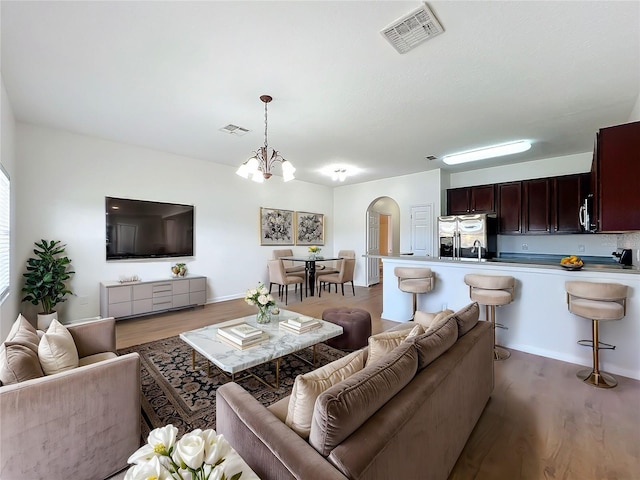 living room with hardwood / wood-style flooring and a notable chandelier