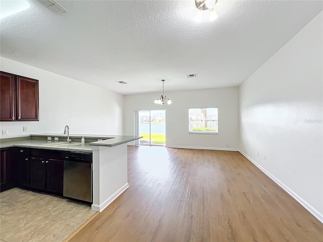 kitchen featuring sink, an inviting chandelier, decorative light fixtures, light wood-type flooring, and stainless steel dishwasher