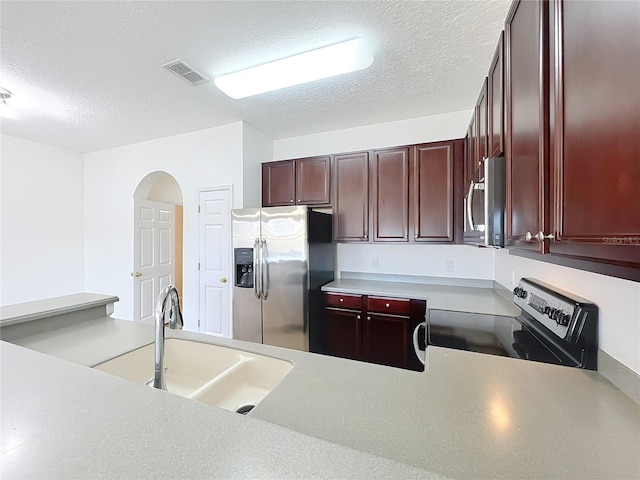 kitchen featuring appliances with stainless steel finishes, sink, and a textured ceiling