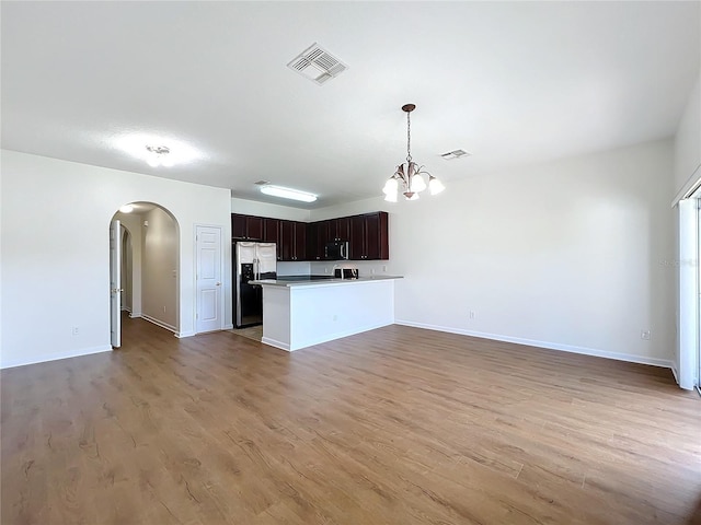 kitchen with pendant lighting, light hardwood / wood-style flooring, stainless steel appliances, and an inviting chandelier