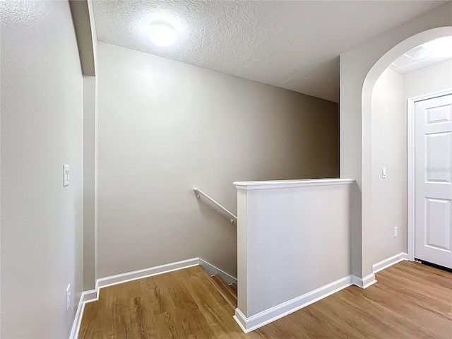 corridor featuring hardwood / wood-style flooring and a textured ceiling