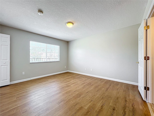 spare room with light hardwood / wood-style flooring and a textured ceiling