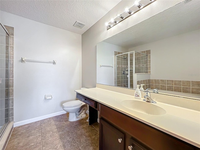 bathroom with a shower with door, vanity, a textured ceiling, tile patterned floors, and toilet