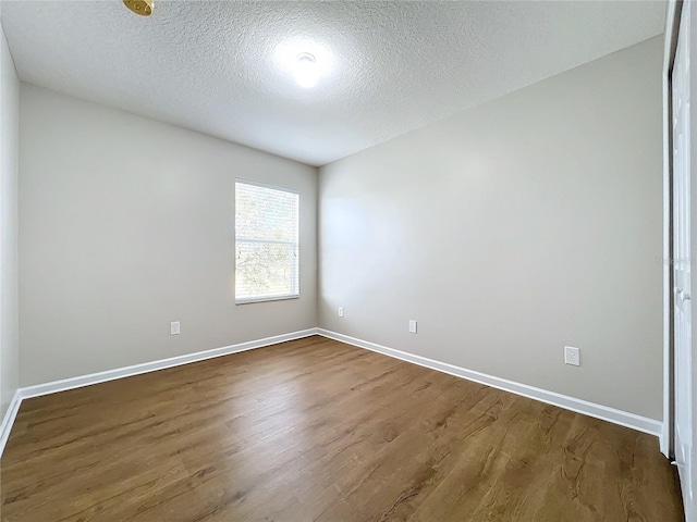 unfurnished room with dark hardwood / wood-style floors and a textured ceiling