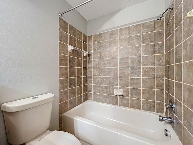 bathroom with tiled shower / bath combo and toilet