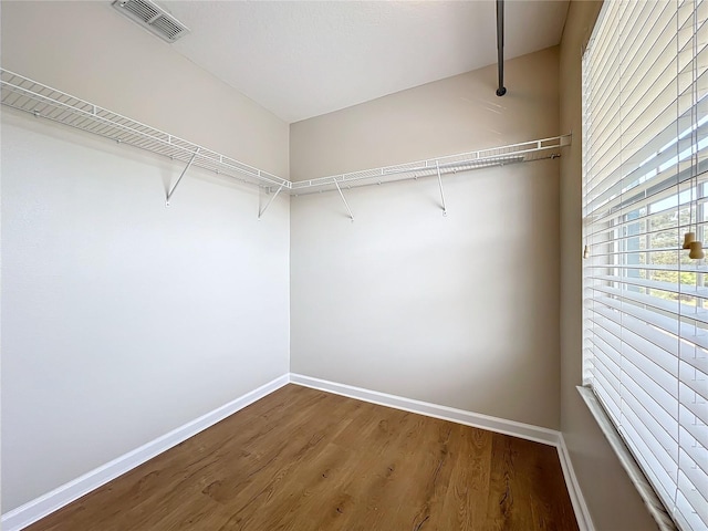 walk in closet with hardwood / wood-style floors