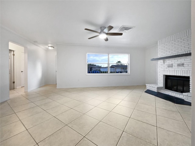 unfurnished living room featuring ceiling fan, light tile patterned floors, a brick fireplace, and ornamental molding