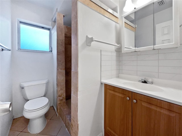 bathroom featuring tile patterned flooring, toilet, walk in shower, vanity, and decorative backsplash