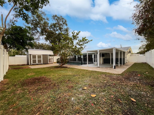 rear view of house featuring a patio area, a lawn, and a shed